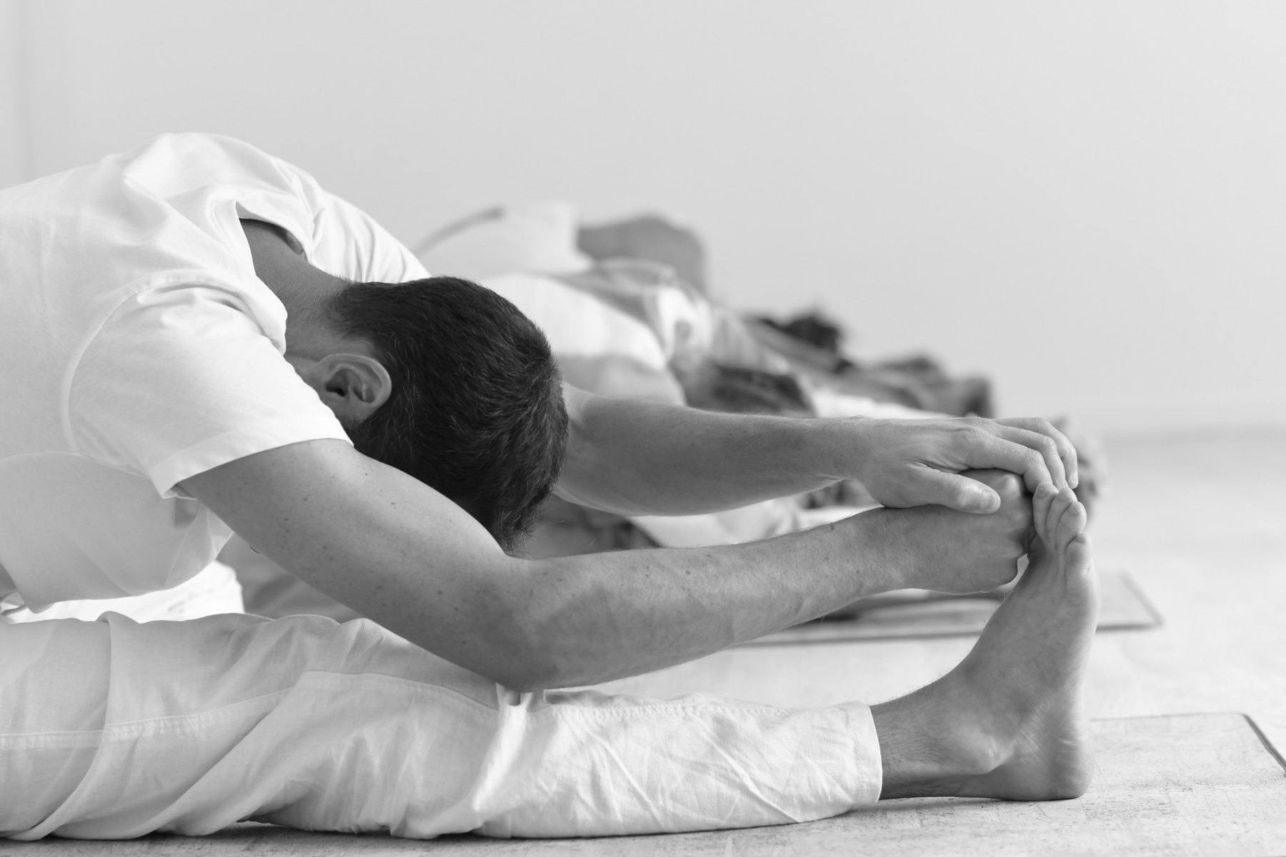 Students practising seated forward fold in class